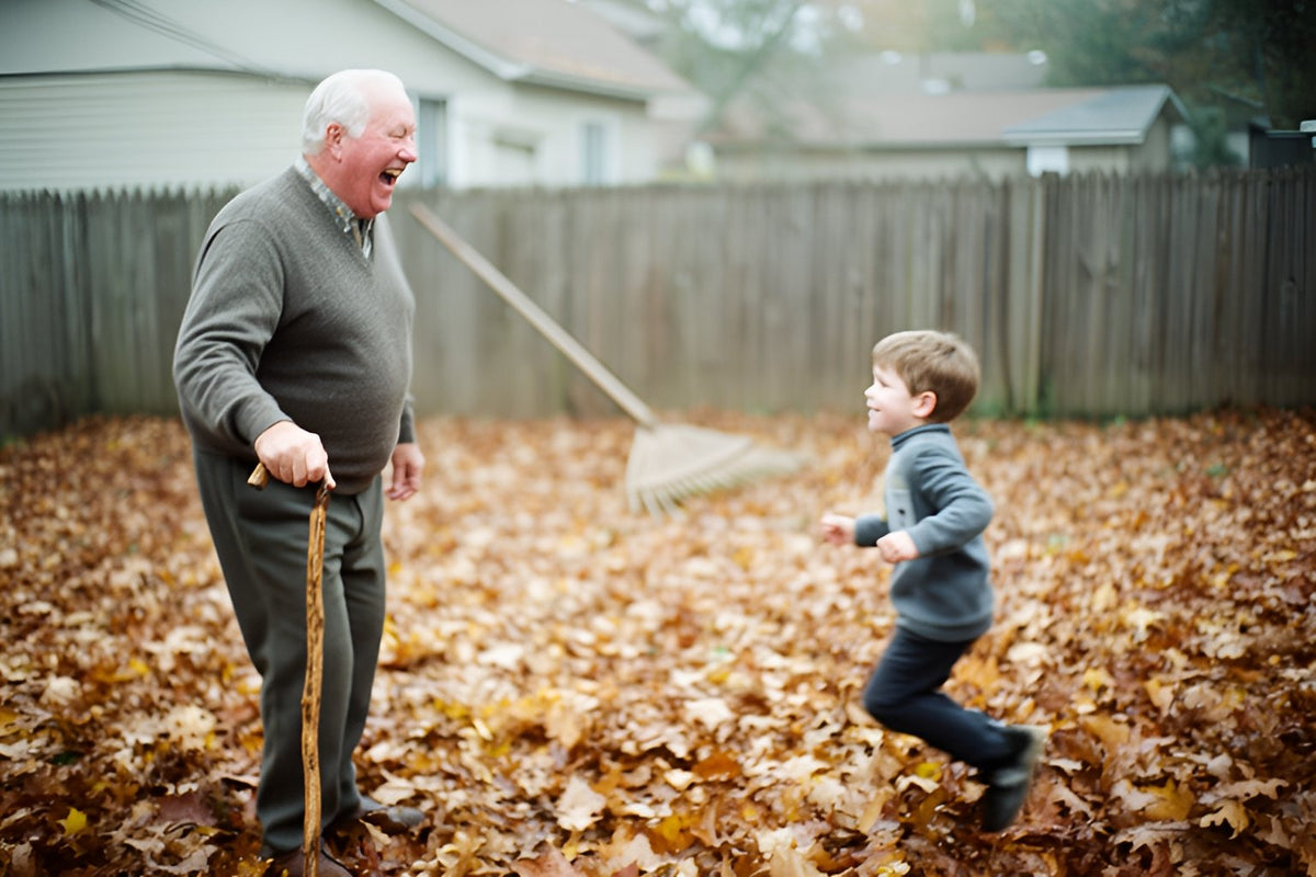 An older man holding a wooden cane laughs as his young grandson runs toward him across a backyard covered in autumn leaves.