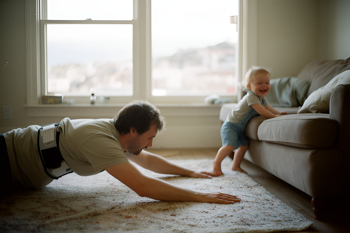 A man in a back support belt stretches on the living room rug while his toddler giggles beside the sofa.